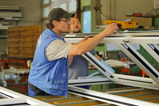 Ein Mitarbeiter von Metallbau SIEG schraubt an einer Fenstertür