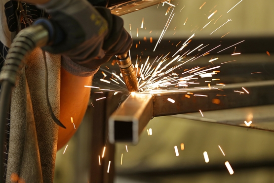 Ein Metallrahmen wird geschweißt, Funken fliegen.